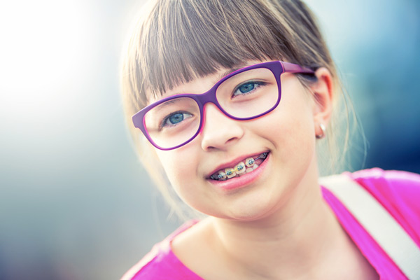 Young girl with glasses receiving early treatment and wearing braces from Lakewood Dental Arts in Lakewood, CA
