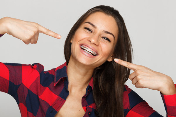 Beautiful female patient of Lakewood Dental Arts smiling with braces in Lakewood, CA