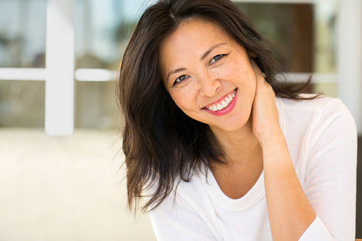 Female patient smiling after receiving dental implants from Lakewood Dental Arts in Lakewood, CA